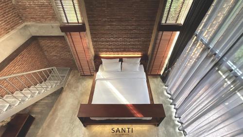 a bedroom with a bed in a room with windows at SANTI beach retreat in Ban Rang Pla