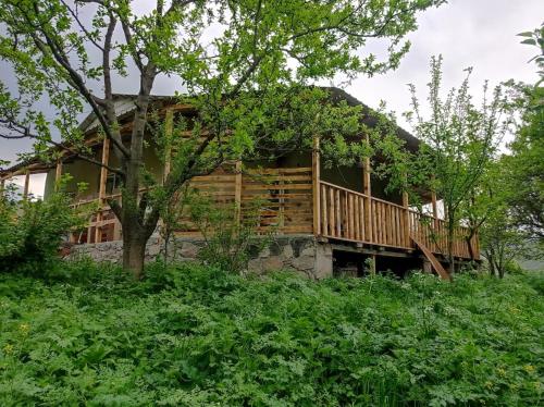 a log house with a deck on a hill at mesxta in Nak'alak'evi