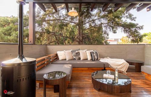 un patio con sofá, mesas y chimenea en Casa Tenancingo by Kukun, en Ciudad de México