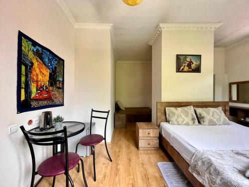 1 dormitorio con 1 cama y 1 mesa con sillas en LA CASA en Tiflis