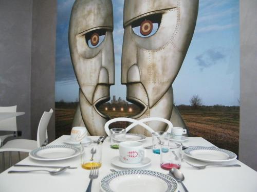 a table with a painting of a face at Villa Floyd Charming Rooms B&B in Pachino