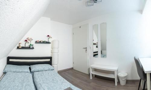 a small white bedroom with a bed and a desk at #1 modernes Zimmer mit Pool und Garten in Memmingen