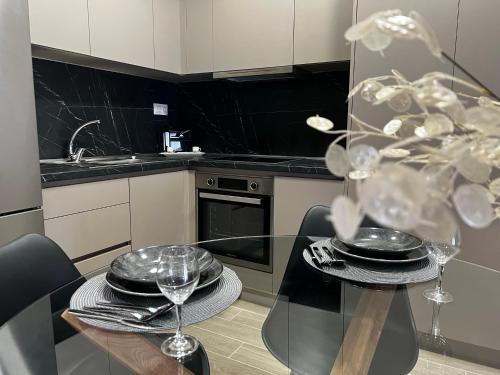 a kitchen with a glass table with plates and wine glasses at Urban Gem by Homebrain in Alexandroupoli