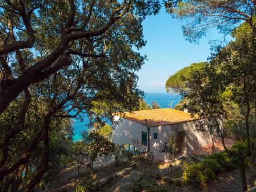 a house on a hill with the ocean in the background at Villa I Coralli in Portoferraio