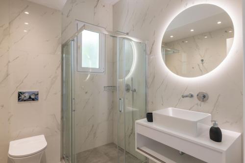 een badkamer met een douche, een wastafel en een spiegel bij Island Hills in Rhodos-stad