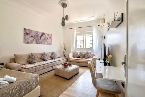 a living room with two couches and a tv at Appartement Ensolleillé Au coeur De Tanger in Tangier