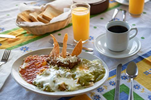 un plato de comida en una mesa con una taza de café en Hotel Hacienda Cola del Caballo, en Santiago