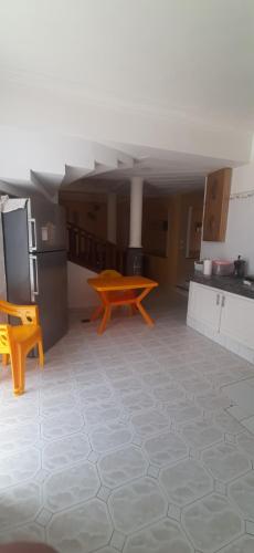 a large kitchen with a table and a refrigerator at Adihou1423 in Bouznika