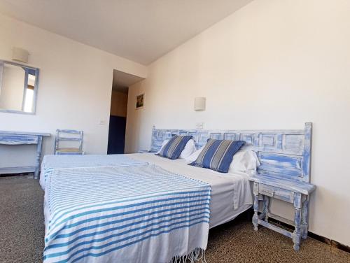 a bedroom with two beds with blue and white sheets at Hostal Santa Ana in Lloret de Mar