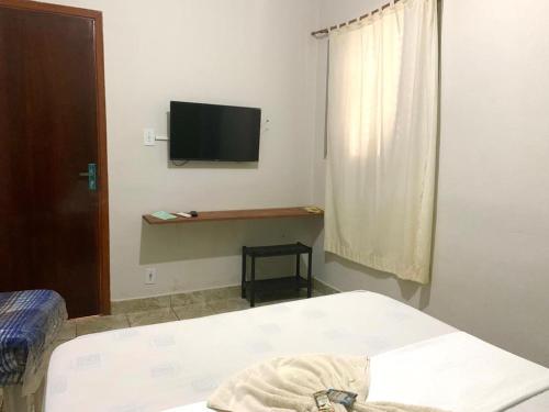 1 dormitorio con 1 cama y TV en la pared en BALSAMO HOTEL, en Marília