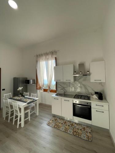 a kitchen with a stove and a table with chairs at Liparulo Holiday House in Massa Lubrense