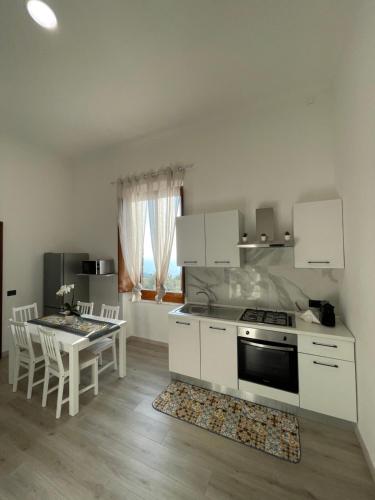 cocina con fogones y mesa con sillas en Liparulo Holiday House, en Massa Lubrense