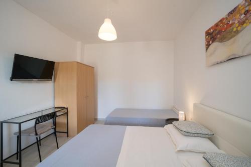 a small bedroom with a bed and a tv at OliveUm Apartments in Umag