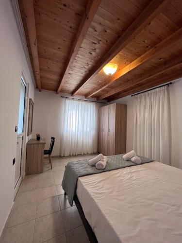 ein Schlafzimmer mit einem großen Bett in einem Zimmer mit Holzdecken in der Unterkunft Kosaris Cottage in Zipárion