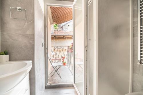 a bathroom with a glass door leading to a patio at Casetta Lago Maggiore in Maccagno Superiore