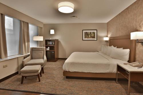 a hotel room with a bed and a desk and a chair at Kahler Grand Hotel in Rochester