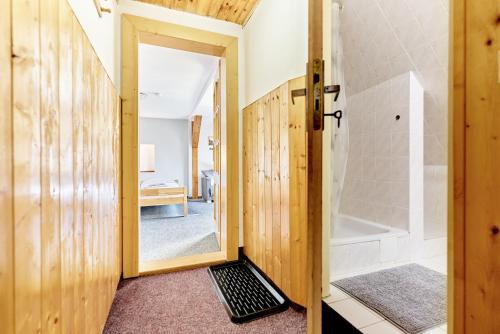baño con ducha y puerta trasera con ducha a ras de suelo en Pension Barborka, en Boží Dar