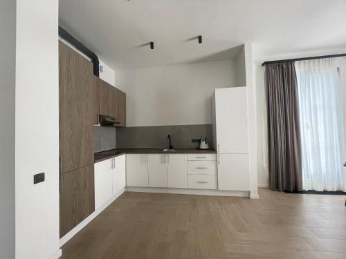 a kitchen with white cabinets and a wooden floor at Aurora Luxe in Dilijan