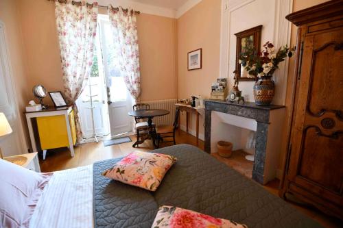 a bedroom with a bed and a fireplace and a window at Domaine de Plisseau in Le Rigalet