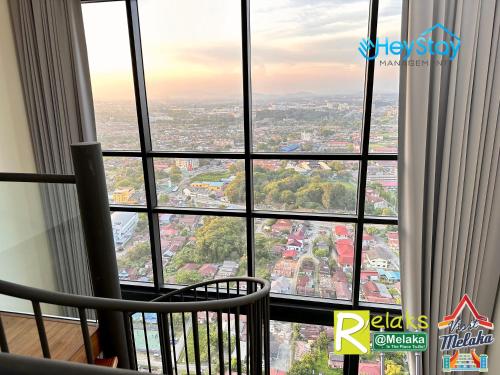 a room with a view of a city from a window at The Apple Residence By Heystay Management in Melaka