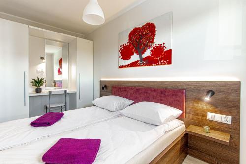 a bedroom with a large bed with purple towels on it at Dobre Smaki Apartaments Chill and Food in Sarbinowo