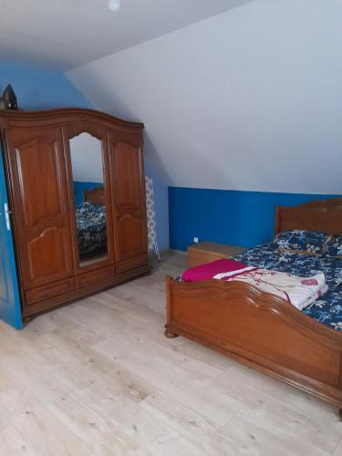 een slaapkamer met een houten bed en een dressoir bij Maison au calme centre ville in Calais