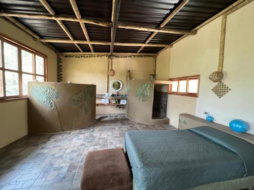 a bedroom with a bed in a room with windows at Villas Adriana, Palenque in Palenque