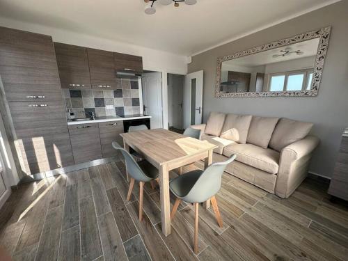 un salon avec une table, des chaises et un canapé dans l'établissement Face à la mer, appartement RDC Bray dunes, à Bray-Dunes
