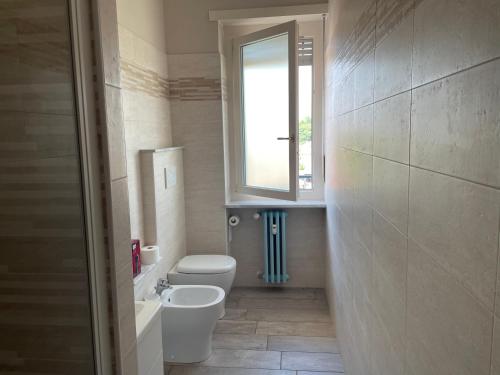 a bathroom with a toilet and a window at Rosa vacanza e o lavoro in Nichelino