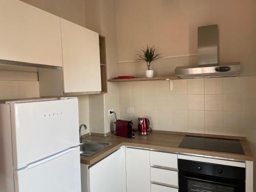 a kitchen with white cabinets and a white refrigerator at Rosa vacanza e o lavoro in Nichelino