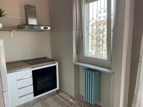a small kitchen with a window and a stove at Rosa vacanza e o lavoro in Nichelino