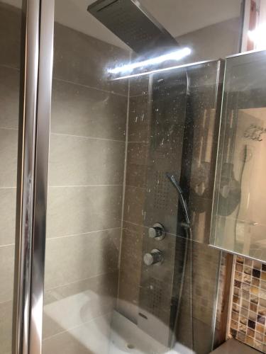une douche avec une porte vitrée dans une salle de bain dans l'établissement T2 50 m de la mer quartier mourillon toulon, à Toulon