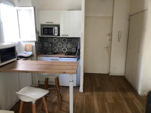 - une cuisine avec une table et des chaises en bois dans la chambre dans l'établissement T2 50 m de la mer quartier mourillon toulon, à Toulon
