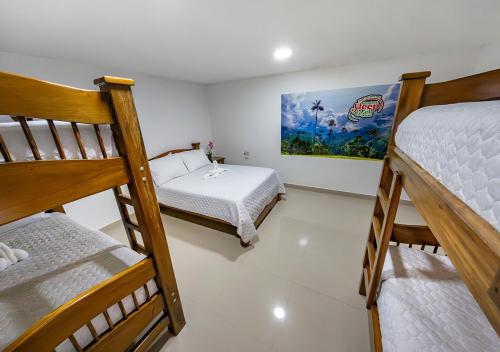 Zimmer mit 2 Etagenbetten und einem kleinen Bett in der Unterkunft Sleep Well in Filandia