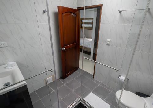 a bathroom with a shower with a toilet and a sink at Sleep Well in Filandia