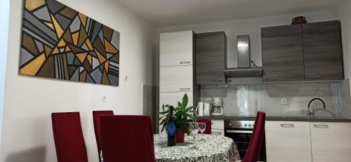 a kitchen with a table with red chairs and a kitchen with at Apartments Desa Petric in Hvar