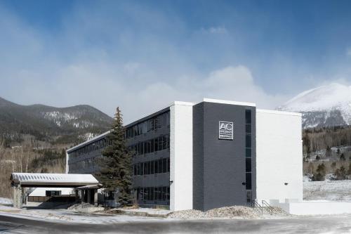 a building with a snow covered mountain in the background at AC Hotel Frisco Colorado in Frisco