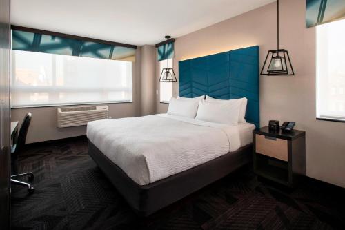 um quarto com uma cama grande e 2 janelas em Four Points by Sheraton Manhattan SoHo Village em Nova York