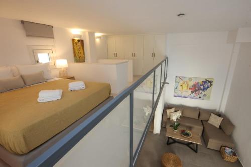 Un pequeño dormitorio con una cama y una escalera en Modern Loft Syros, en Ano Syros