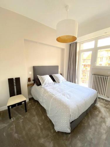 une chambre avec un grand lit et une chaise dans l'établissement T3 de 73 m2 , garage , vue montagnes et château, à Annecy