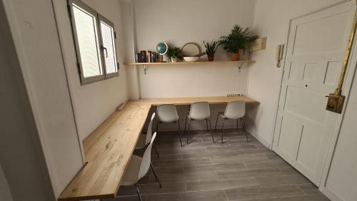 Cette chambre dispose d'une porte et d'une table avec des chaises en bois. dans l'établissement The Wave Temple, à Las Palmas de Gran Canaria