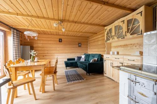 a kitchen and living room with a wooden ceiling at Domek Hacienda in Kościelisko