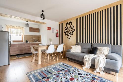 ein Wohnzimmer mit einem Sofa und einem Tisch in der Unterkunft Domek Hacienda in Kościelisko