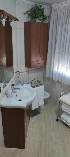 a bathroom with a white sink and a toilet at Piso As Rodas in Villanueva de Arosa
