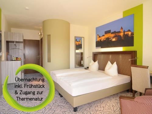 ein Hotelzimmer mit einem Bett und einem grünen Schild in der Unterkunft Kurhotel Bad Rodach an der ThermeNatur in Bad Rodach