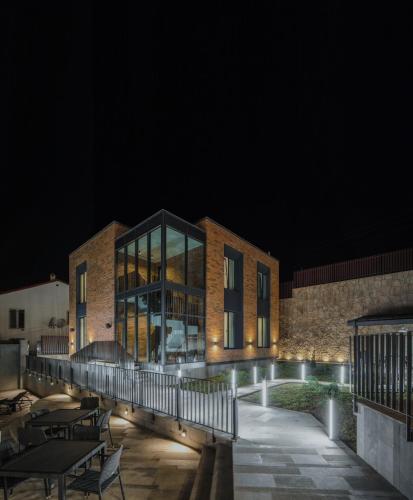 a brick building at night with tables and chairs at Aurora Luxe in Dilijan