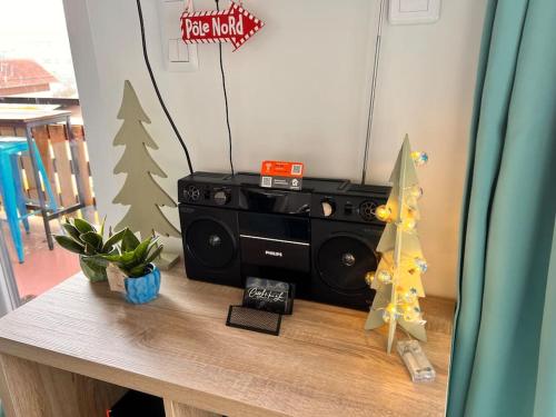 a table with a speaker and a christmas tree on it at Chalet Charmant rénové au bord du Lac St Point in Montperreux