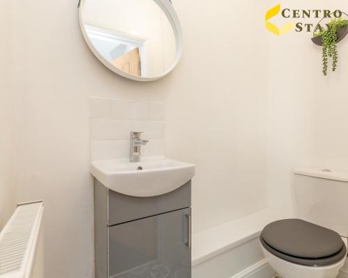 a bathroom with a sink and a toilet and a mirror at 5-10percent Off Week or Month Stay - Group, Family or Work Relocation FREE PARKING in Northampton