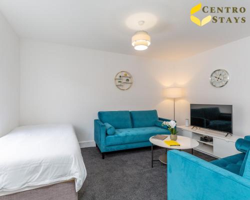 a bedroom with a bed and a couch and a table at Central 2 to 3BR House, Free Parking, Ideal for Long Stays, Work Crews & Family Trips in Northampton