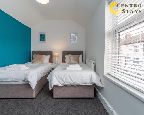 two twin beds in a bedroom with a window at 5-10percent Off Week or Month Stay - Group, Family or Work Relocation FREE PARKING in Northampton